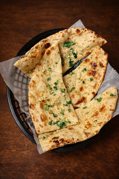 Table spread with naan, rice, curries, and sides